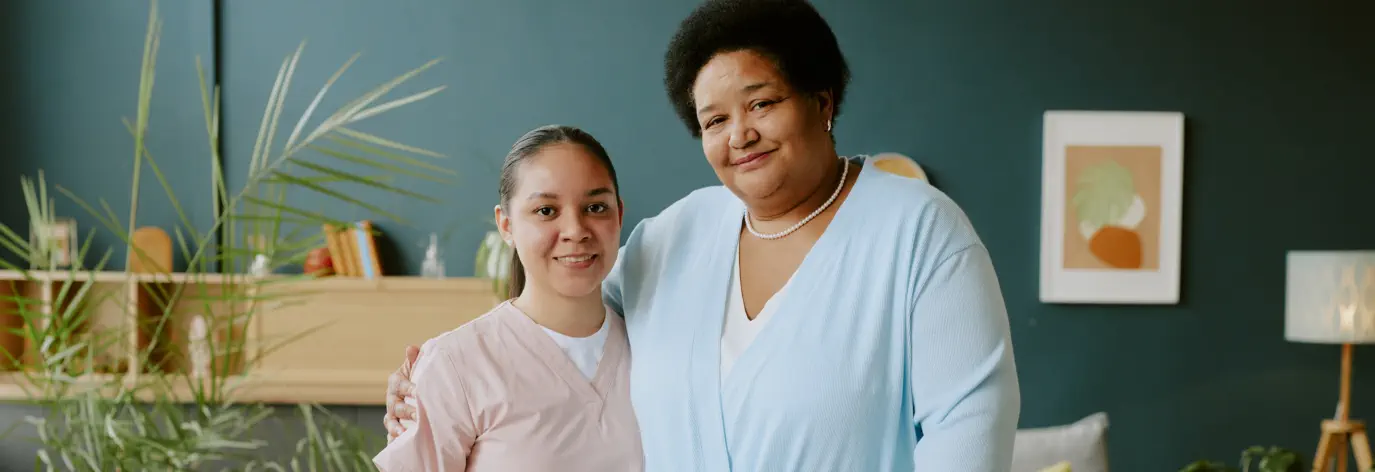 caregiver and an elderly smiling in a cozy room