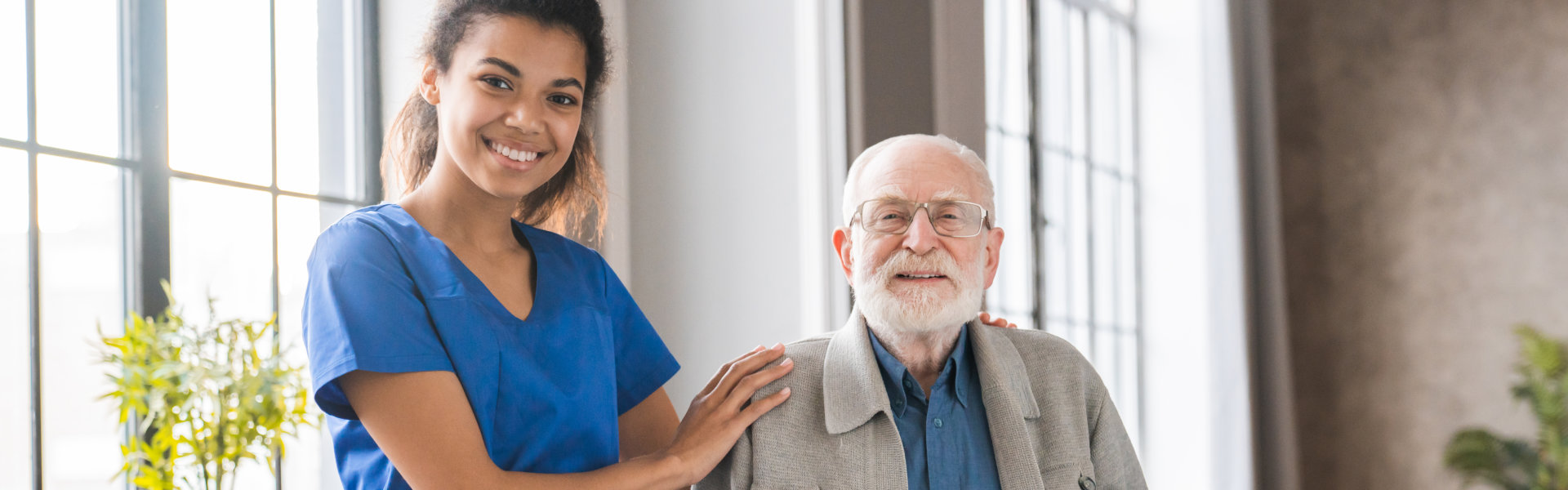 caregiver and an elderly smiling and staring